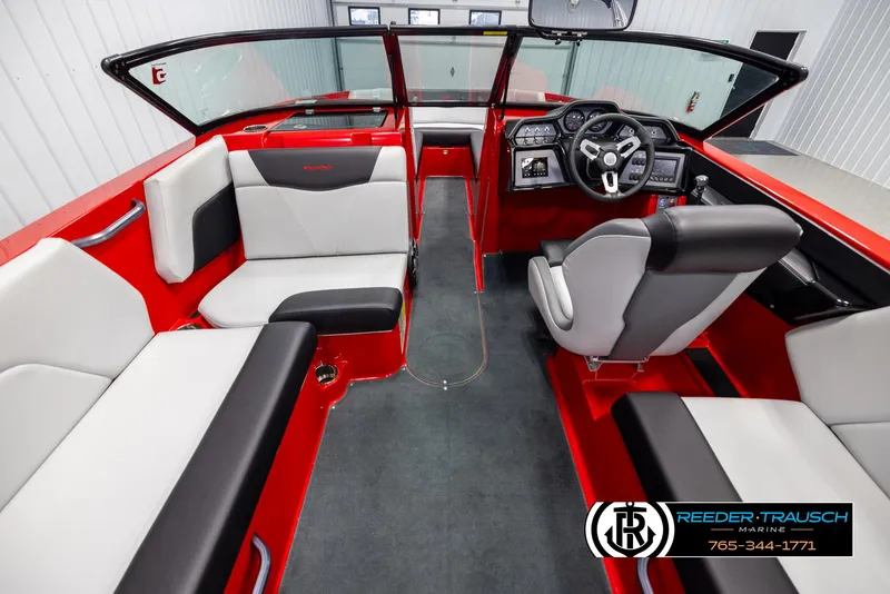 Slide: The Image of 2021 MasterCraft NXT24 boat interior with red and gray seating, steering console, and windshield. - 14