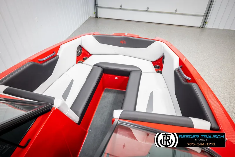 Slide: The Image of 2021 MasterCraft NXT24 boat interior with red and white seating in a showroom. - 19