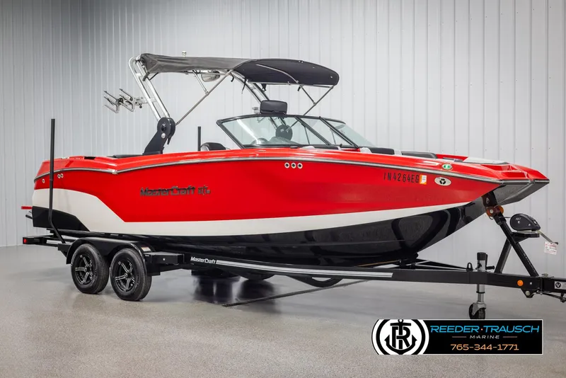 Slide: The Image of 2021 MasterCraft NXT24 boat in vibrant red on a trailer, displayed indoors. - 3