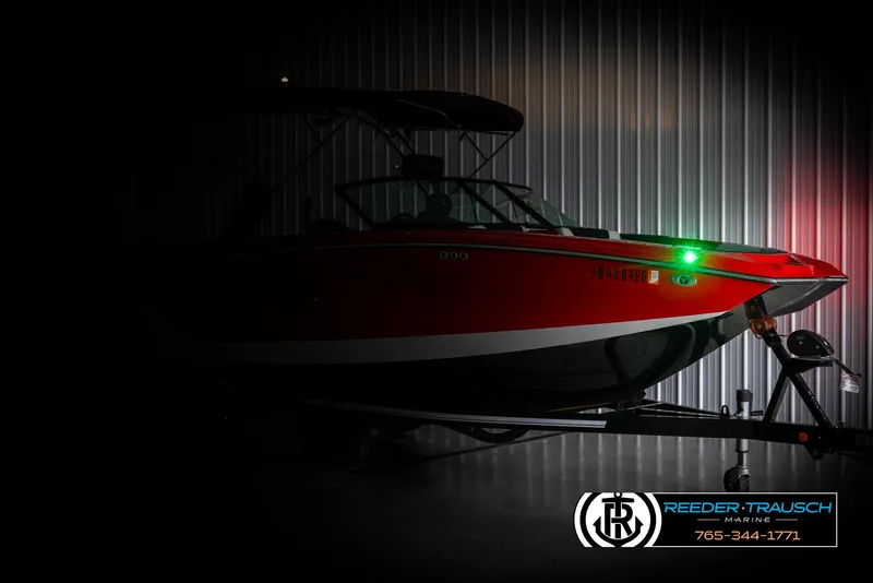Slide: The Image of 2021 MasterCraft NXT24 boat in dimly lit storage, side view. - 4