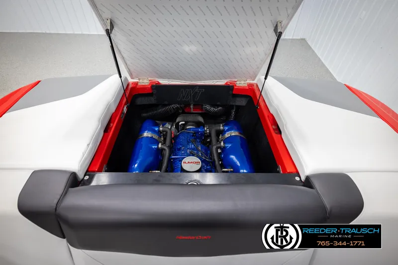 Slide: The Image of 2021 MasterCraft NXT24 boat engine compartment with blue components, open hatch. - 48
