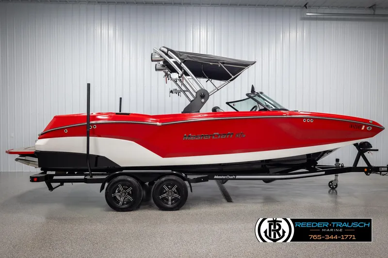 Slide: The Image of 2021 MasterCraft NXT24 red boat on trailer in showroom. - 5