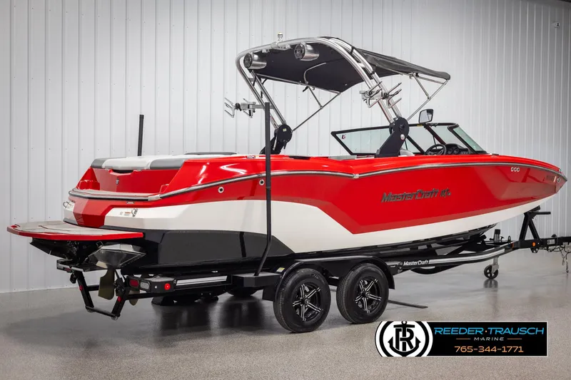 Slide: The Image of 2021 MasterCraft NXT24 boat in vibrant red on a trailer, side view. - 6