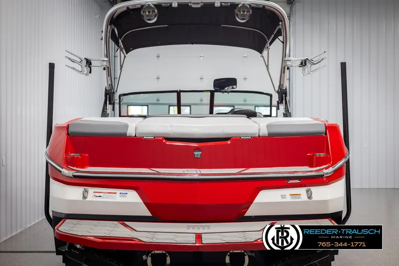 Slide: The Image of 2021 MasterCraft NXT24 boat, red and white, rear view in a showroom. - 7