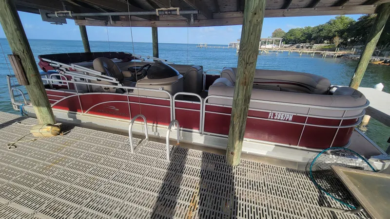 Slide: The Image of 2012 Bennington 2274 GL pontoon boat docked by a scenic lake. - 11