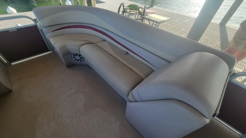 Slide: The Image of 2012 Bennington 2274 GL boat interior with beige seating and red accents. - 14