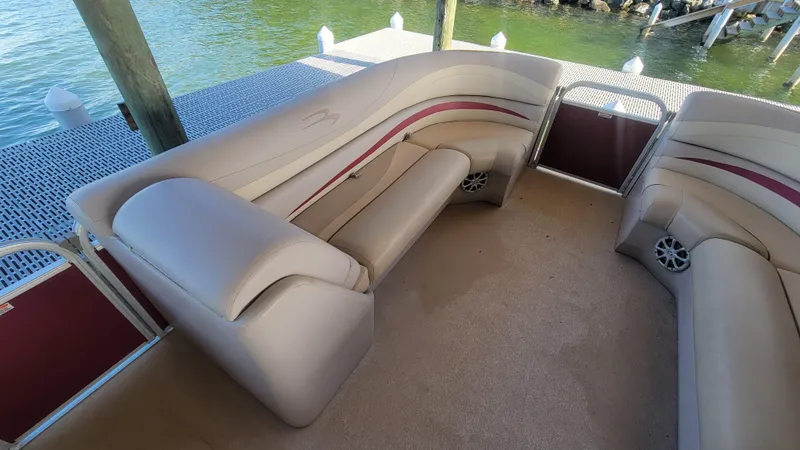 Slide: The Image of 2012 Bennington 2274 GL pontoon boat interior with beige seating and water view. - 18