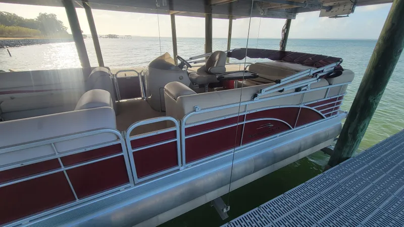 Slide: The Image of 2012 Bennington 2274 GL pontoon boat docked on calm water under a canopy. - 21