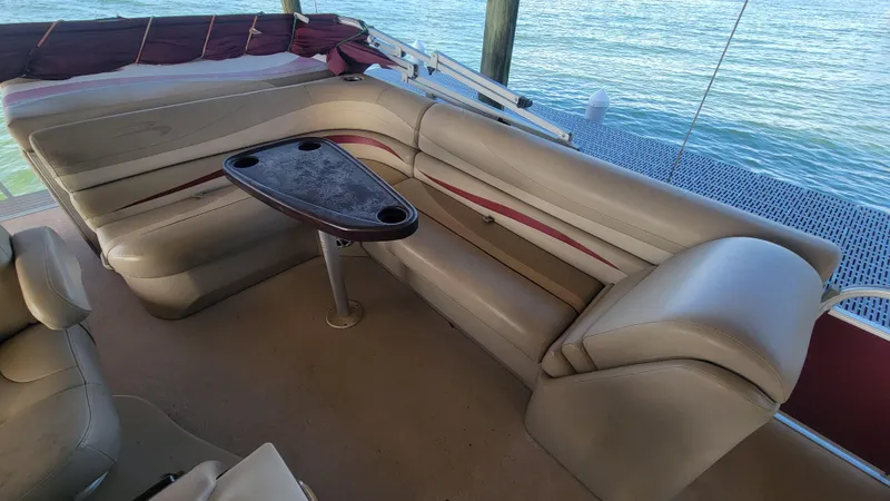 Slide: The Image of 2012 Bennington 2274 GL boat interior with beige seating and a small table. - 22