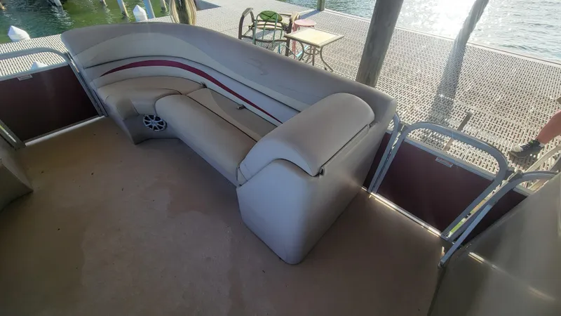 Slide: The Image of 2012 Bennington 2274 GL pontoon boat interior with cushioned seating and lake view. - 23