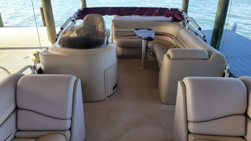 Slide: The Image of 2012 Bennington 2274 GL pontoon boat interior with plush seating and table. - 5