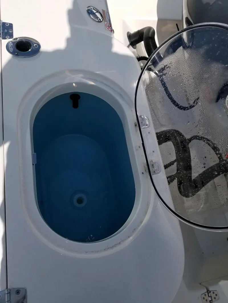 Slide: The Image of Cobia 280 Center Console 2020 livewell with open lid and water inside. - 11