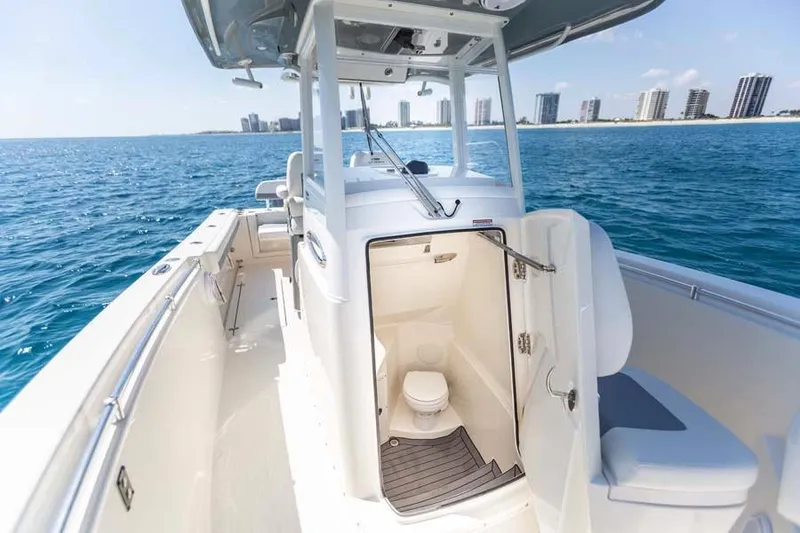 Slide: The Image of 2020 Cobia 280 Center Console boat with open cabin door on ocean. - 14