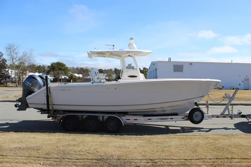 Slide: The Image of 2020 Cobia 280 Center Console boat on trailer, parked outdoors. - 2