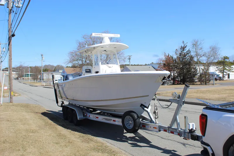 Slide: The Image of 2020 Cobia 280 Center Console boat on trailer, parked on a street. - 3