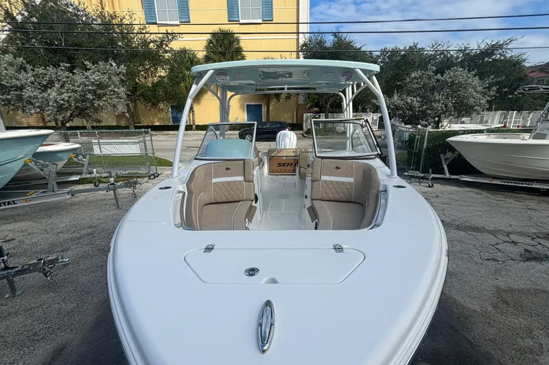 Slide: The Image of 2025 Sea Pro 240 Dual Console boat, white exterior, parked outdoors. - 7