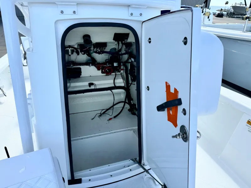 Slide: The Image of Open storage compartment on 2025 BlackJack 256 Bay boat, showing interior wiring and equipment. - 13