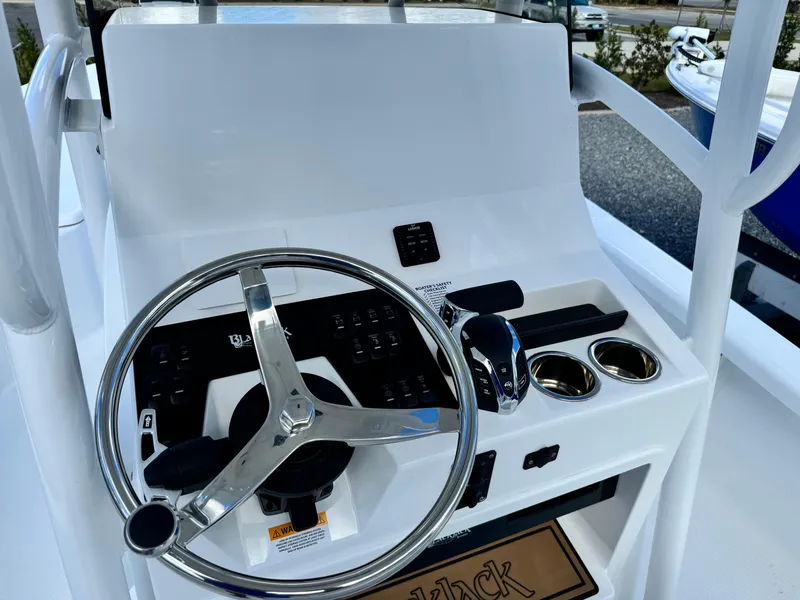 Slide: The Image of 2025 BlackJack 256 Bay boat console with steering wheel and controls. - 16