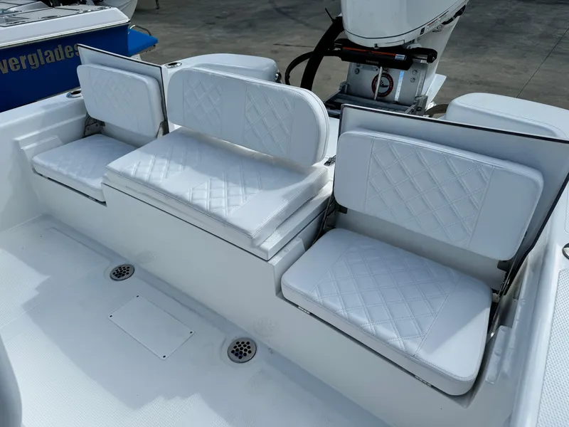 Slide: The Image of 2025 BlackJack 256 Bay boat with white cushioned seating and motor. - 20