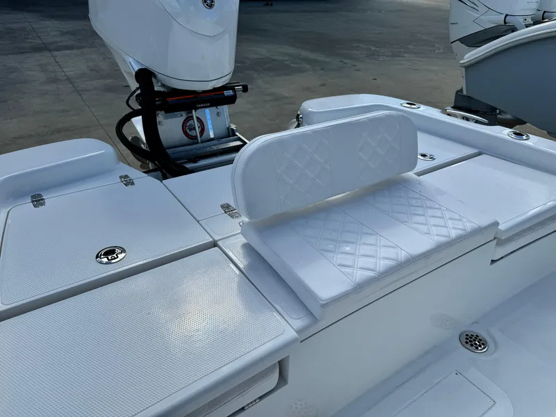 Slide: The Image of 2025 BlackJack 256 Bay boat interior with white cushioned seating and storage compartments. - 22
