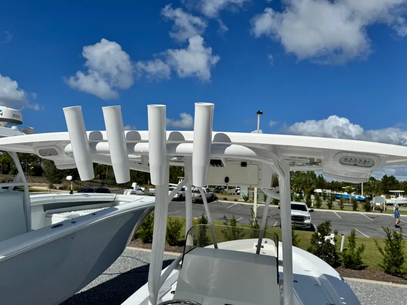 Slide: The Image of 2025 BlackJack 256 Bay boat with rod holders under a clear blue sky. - 28