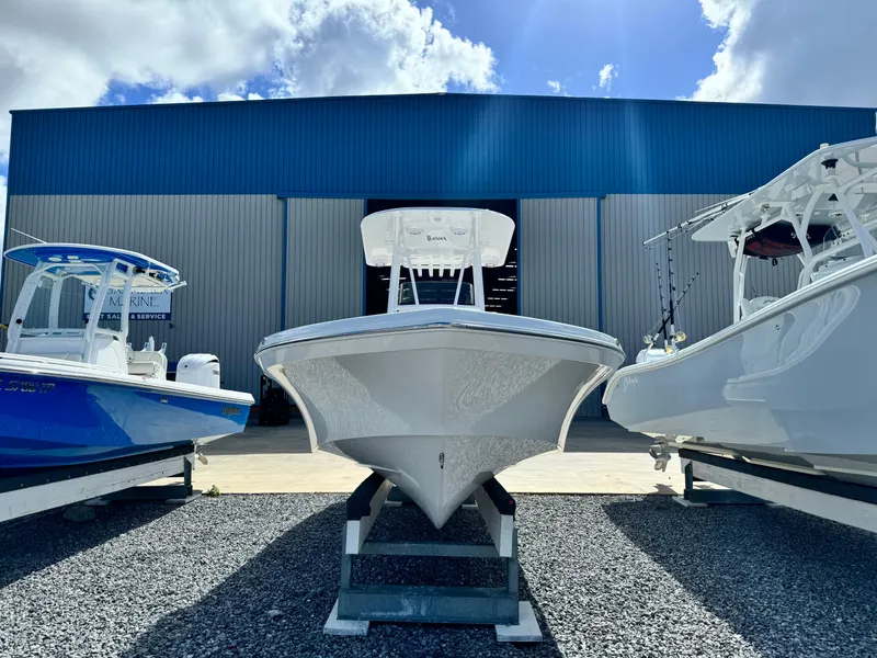 Slide: The Image of 2025 BlackJack 256 Bay boat displayed outdoors between two other boats. - 6