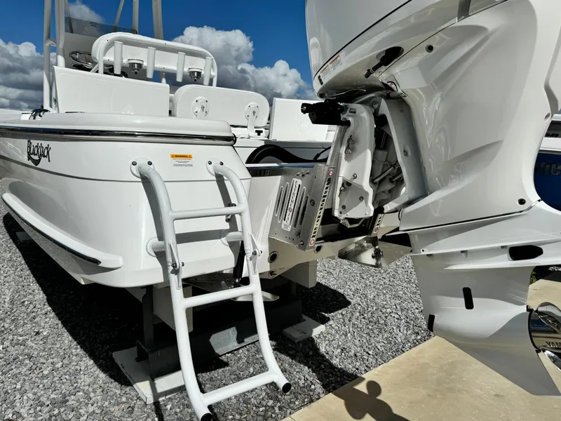 Slide: The Image of 2025 BlackJack 256 Bay boat with ladder and motor, displayed on gravel. - 7