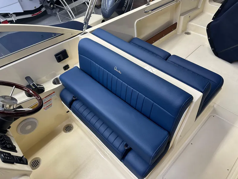 Slide: The Image of 2025 Rossiter 23 boat interior with blue seating and steering wheel. - 11