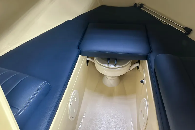 Slide: The Image of 2025 Rossiter 23 boat interior with blue cushioned seating and compact toilet. - 14