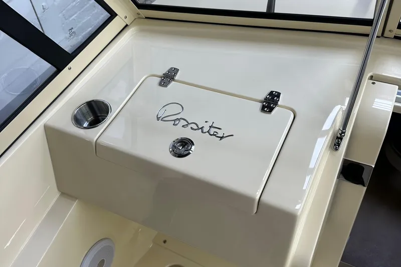 Slide: The Image of 2025 Rossiter 23 boat interior with storage compartment and cup holder. - 17