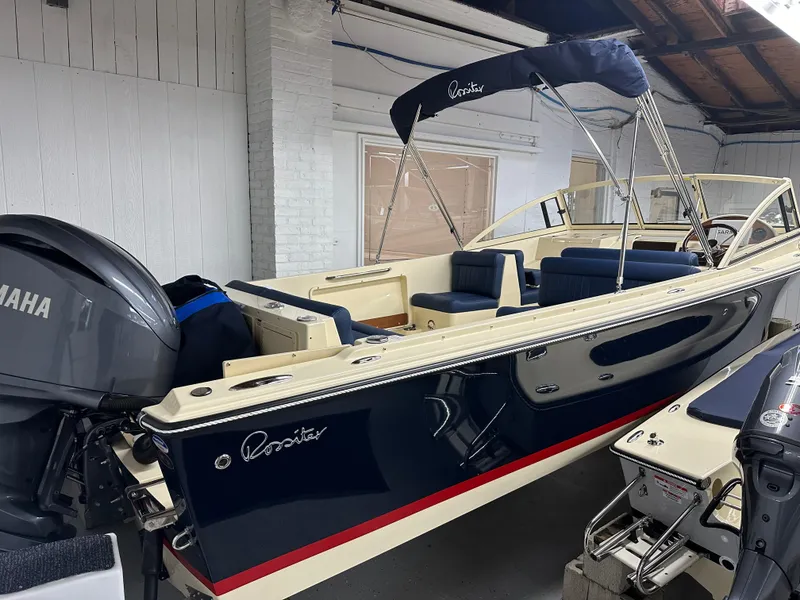 Slide: The Image of 2025 Rossiter 23 boat with Yamaha engine in a garage setting. - 2