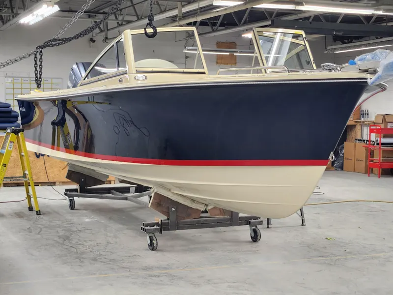 Slide: The Image of 2025 Rossiter 23 boat in workshop, navy and cream design with red stripe. - 3