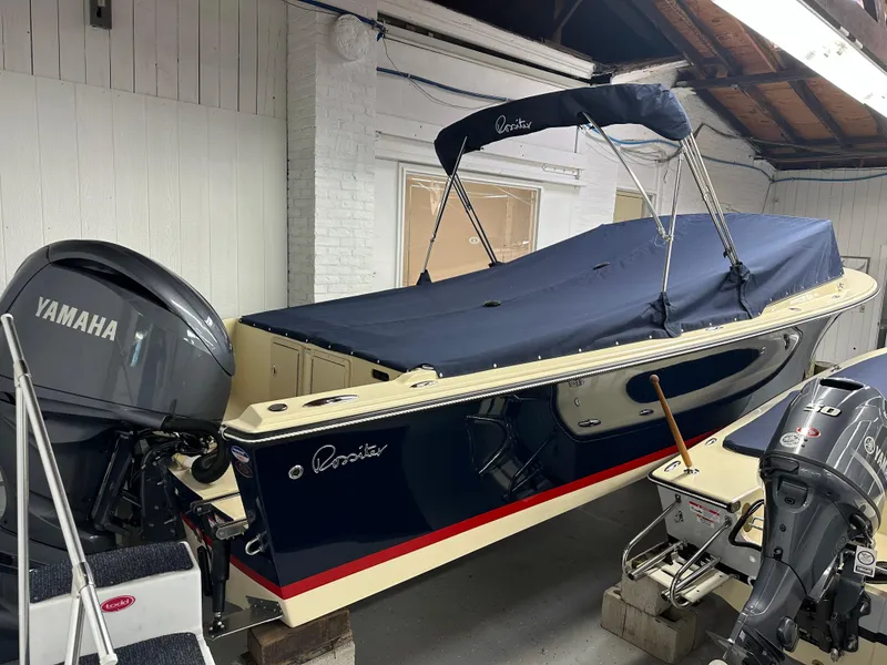 Slide: The Image of 2025 Rossiter 23 boat with Yamaha outboard motor, covered and stored indoors. - 4
