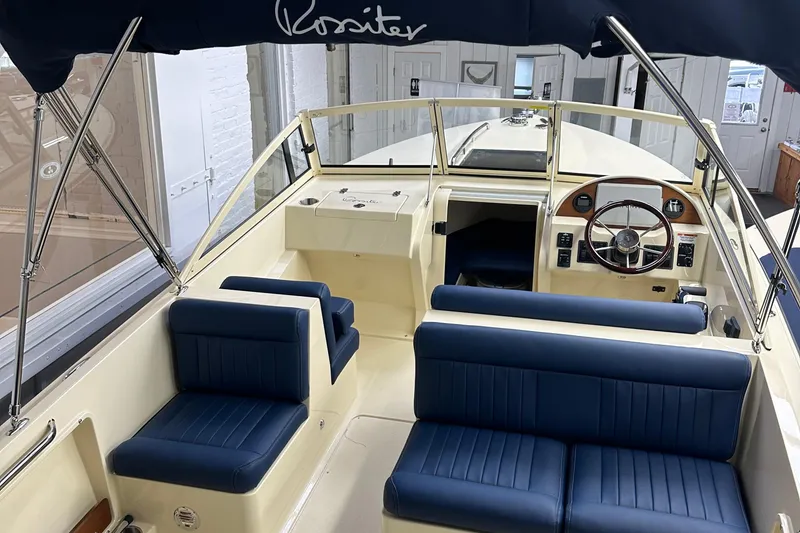 Slide: The Image of 2025 Rossiter 23 boat interior with blue seating and steering wheel. - 5