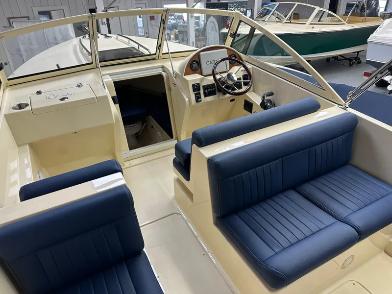 Slide: The Image of 2025 Rossiter 23 boat interior with blue seating and steering wheel. - 9