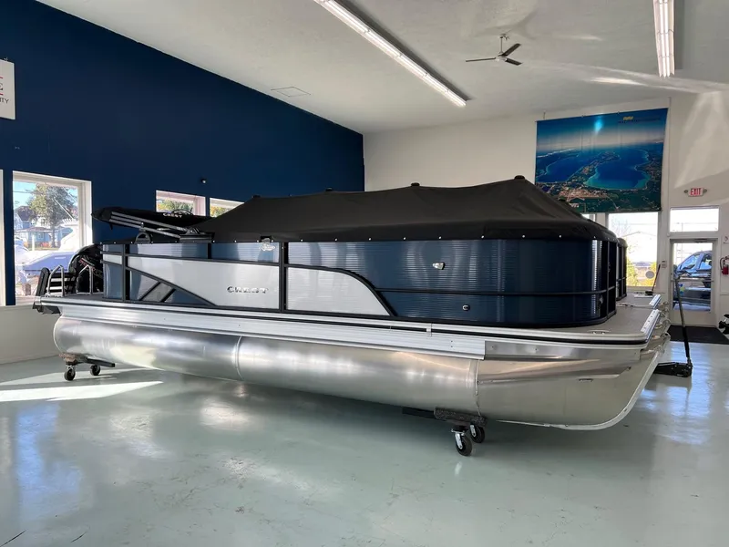The Image of 2025 Crest Classic 220 pontoon boat in showroom, covered and on display. - 1