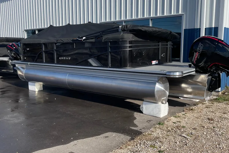 The Image of 2025 Crest CLASSIC 220 L pontoon boat with cover, parked outside a building. - 0