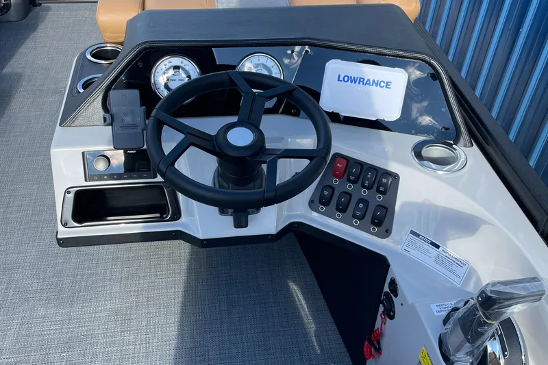 Slide: The Image of 2025 Crest CLASSIC 220 L boat dashboard with steering wheel and Lowrance display. - 10