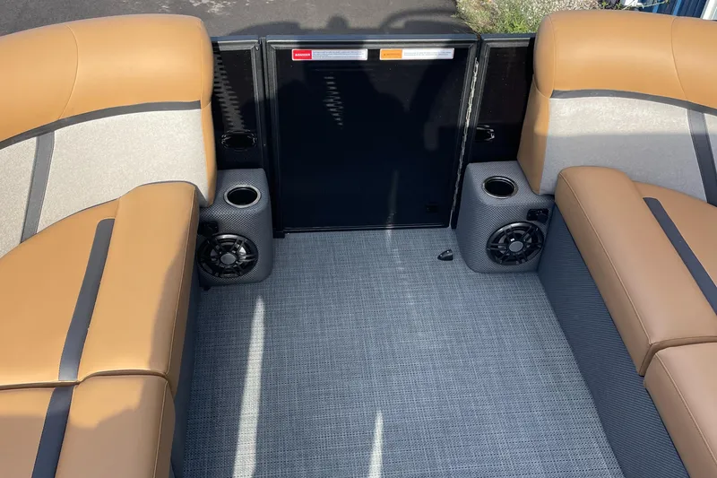 Slide: The Image of 2025 Crest CLASSIC 220 L boat interior with tan seating and built-in speakers. - 15