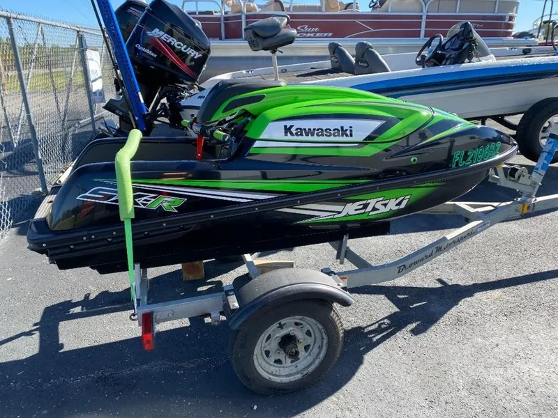 Slide: The Image of 2021 Kawasaki Jetski SX-R on trailer, green and black design, parked outdoors. - 14