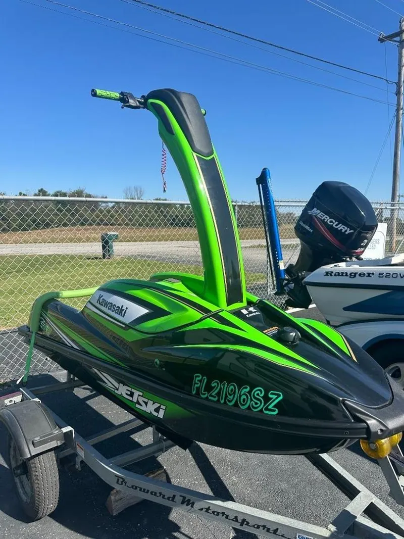 Slide: The Image of 2021 Kawasaki Jetski SX-R in green and black on a trailer, outdoors. - 3