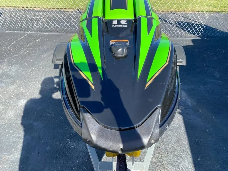 Slide: The Image of 2021 Kawasaki Jetski SX-R in green and black, parked on pavement. - 7