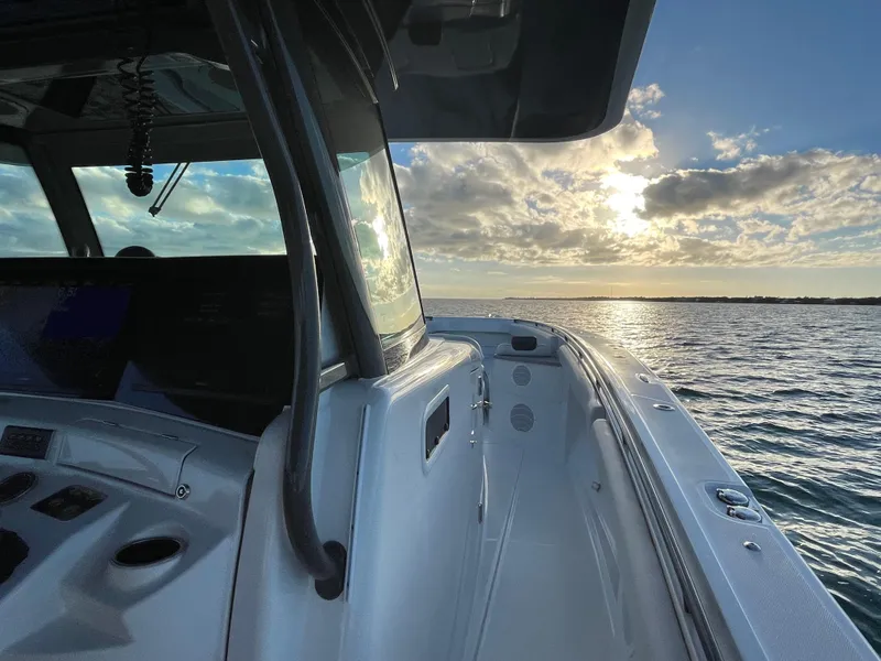 Slide: The Image of 2019 HCB 53 Sueños boat on water at sunset, showcasing sleek design and serene seascape. - 10