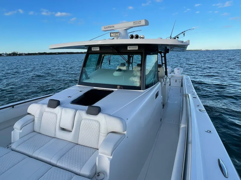 Slide: The Image of 2019 HCB 53 Sueños boat on open water, featuring sleek white design and advanced navigation equipment. - 14