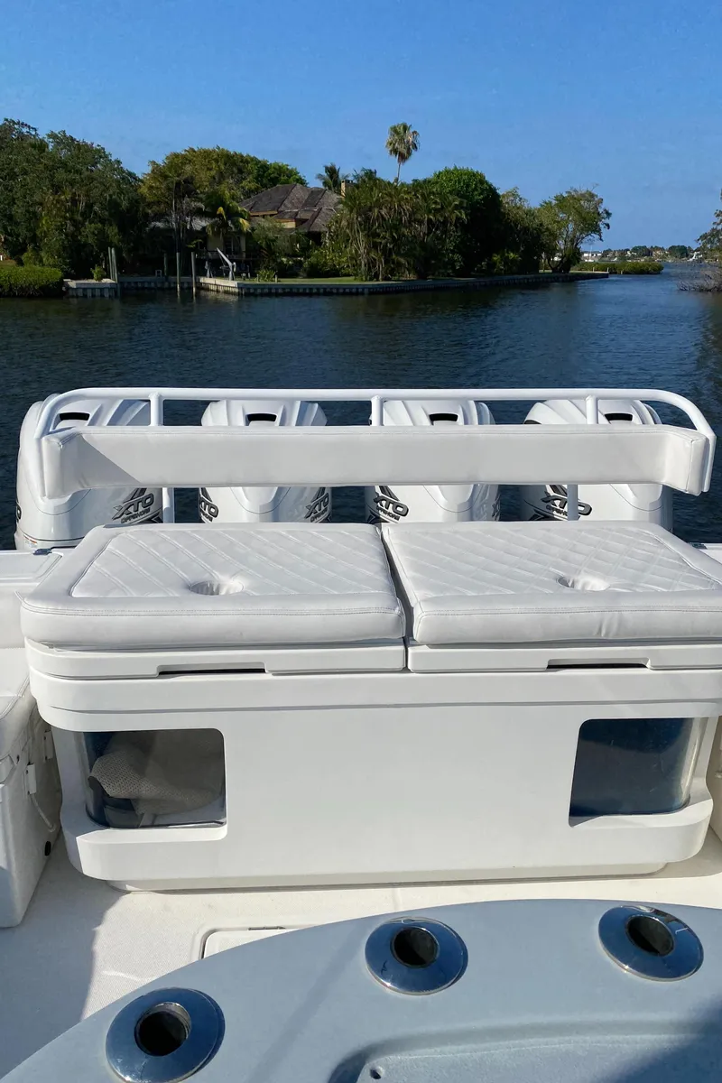 Slide: The Image of 2019 HCB 53 Sueños boat with seating and storage, docked on a serene waterway. - 17