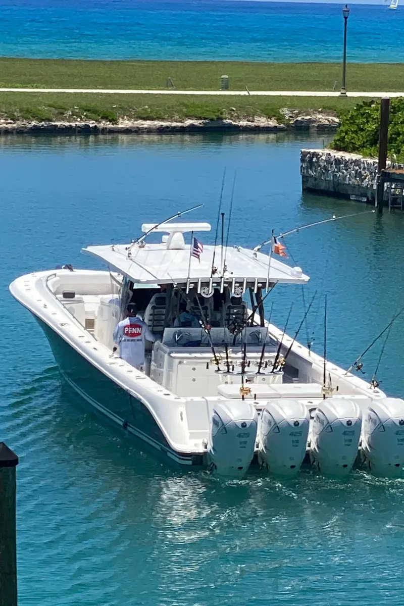 Slide: The Image of 2019 HCB 53 Sueños boat with multiple engines in a serene marina setting. - 18