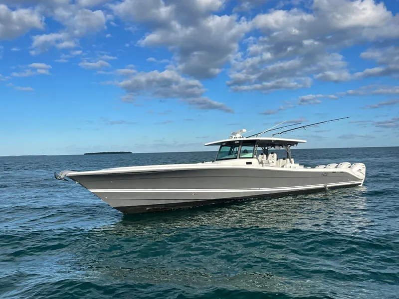 Slide: The Image of 2019 HCB 53 Sueños boat on open water under a partly cloudy sky. - 2