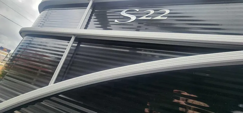 Slide: The Image of 2024 Bennington 22 SL boat exterior with sleek black finish and S22 emblem. - 5