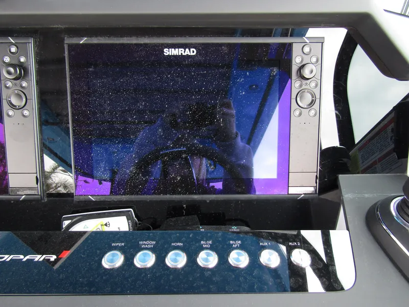 Slide: The Image of 2024 Axopar 37 Sun Top dashboard with Simrad display and control buttons. - 24