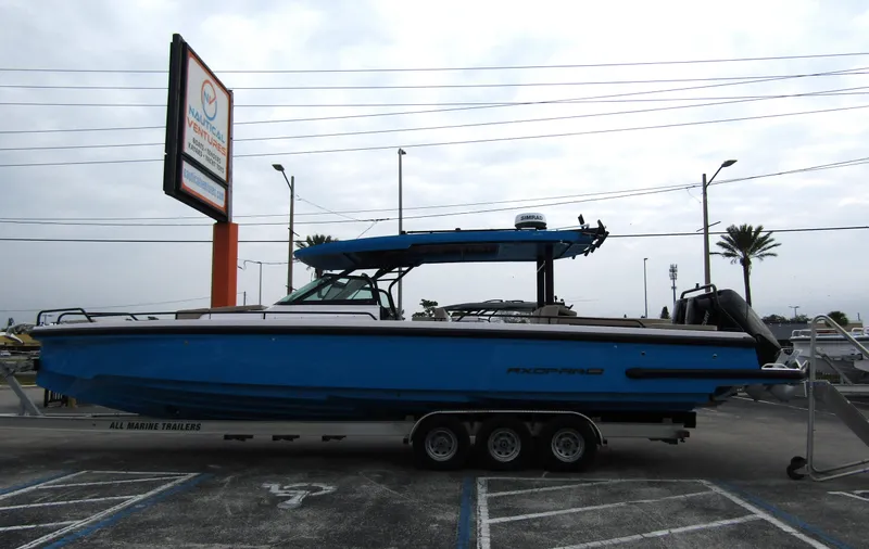 Slide: The Image of 2024 Axopar 37 Sun Top boat in a parking lot, side view. - 3